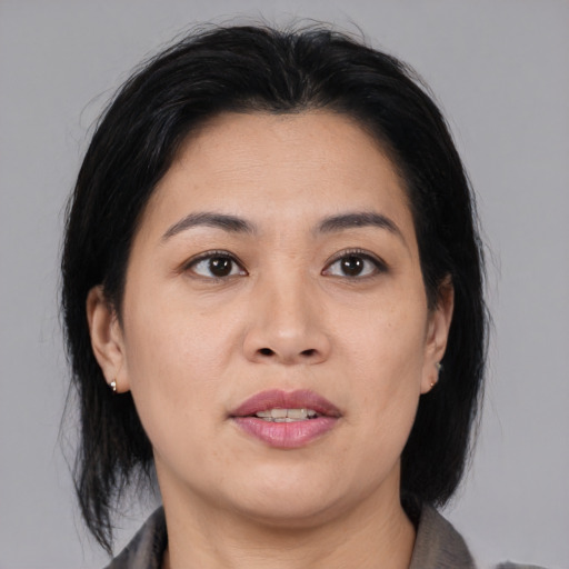 Joyful asian adult female with medium  black hair and brown eyes