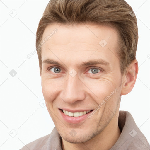 Joyful white young-adult male with short  brown hair and grey eyes