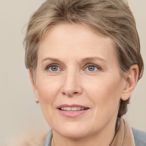 Joyful white adult female with medium  brown hair and grey eyes