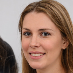 Joyful white young-adult female with long  brown hair and brown eyes