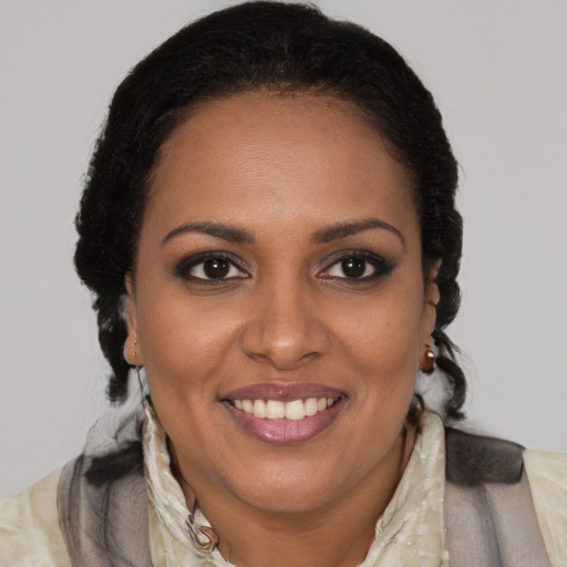 Joyful black adult female with long  brown hair and brown eyes