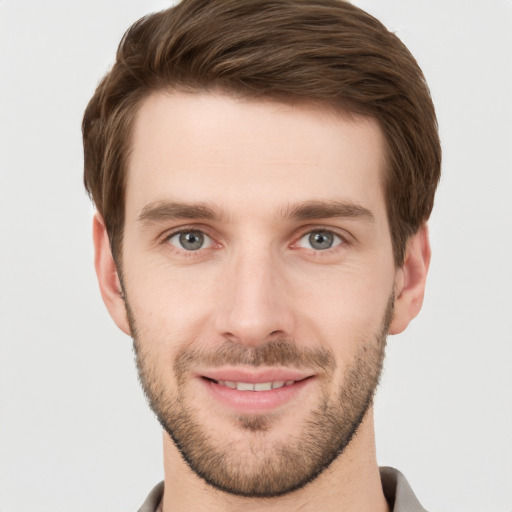 Joyful white young-adult male with short  brown hair and grey eyes