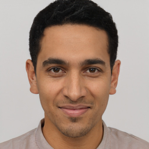 Joyful latino young-adult male with short  black hair and brown eyes