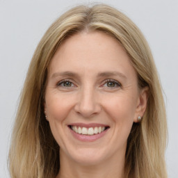 Joyful white adult female with long  brown hair and grey eyes