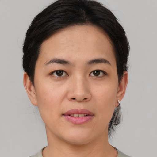 Joyful asian young-adult female with short  brown hair and brown eyes