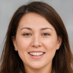 Joyful white young-adult female with long  brown hair and brown eyes