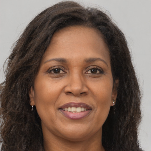 Joyful black adult female with long  brown hair and brown eyes