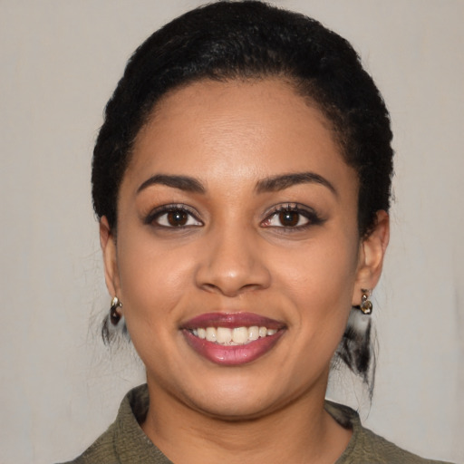 Joyful black young-adult female with short  black hair and brown eyes