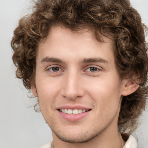 Joyful white young-adult male with medium  brown hair and green eyes