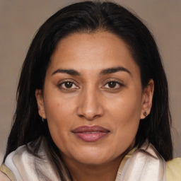 Joyful latino adult female with medium  brown hair and brown eyes