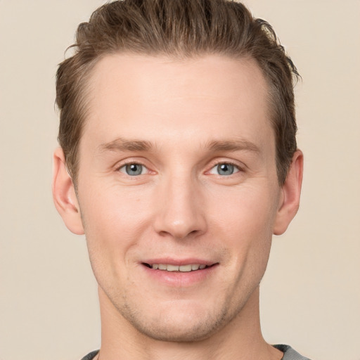 Joyful white young-adult male with short  brown hair and grey eyes