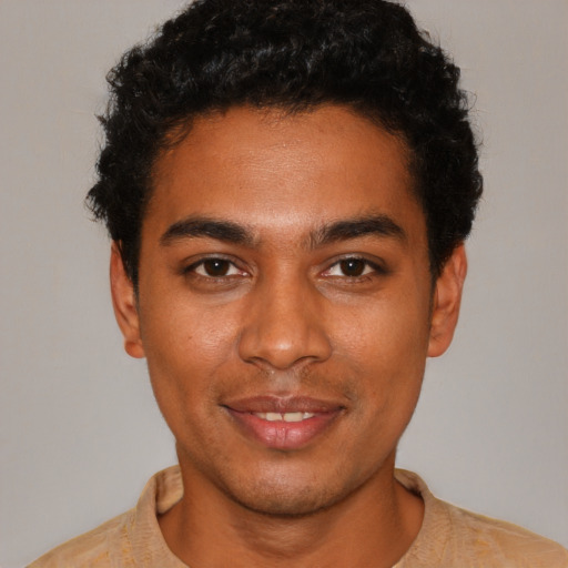 Joyful black young-adult male with short  black hair and brown eyes