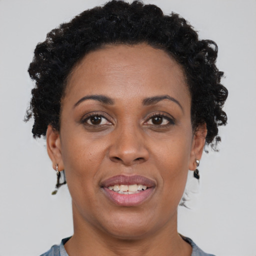 Joyful black adult female with short  brown hair and brown eyes