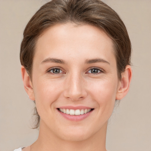 Joyful white young-adult female with short  brown hair and grey eyes