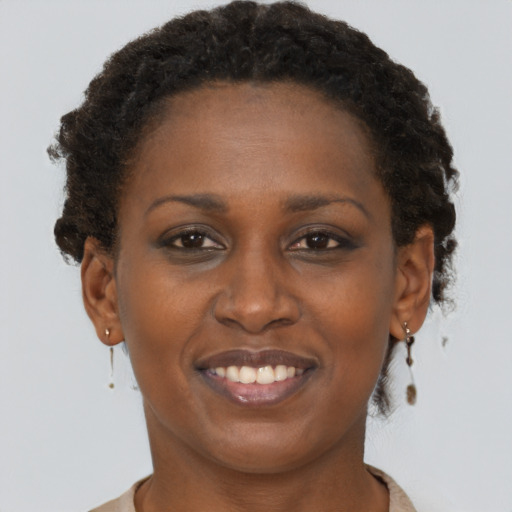 Joyful black adult female with short  brown hair and brown eyes