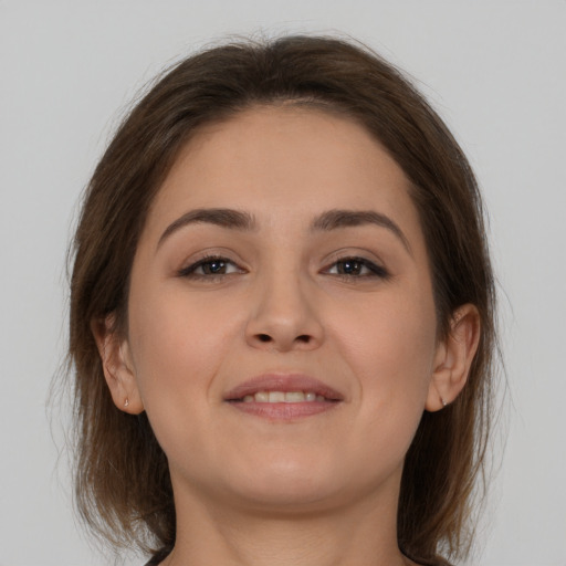 Joyful white young-adult female with medium  brown hair and brown eyes