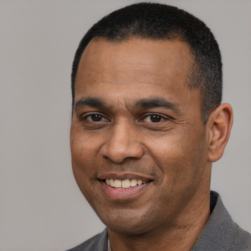 Joyful black adult male with short  black hair and brown eyes