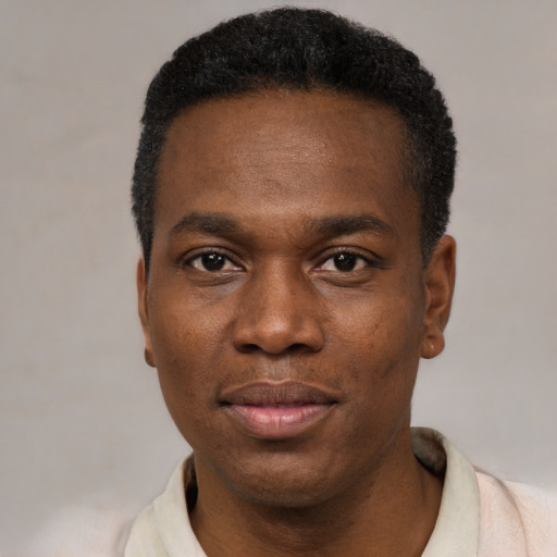 Joyful black young-adult male with short  black hair and brown eyes
