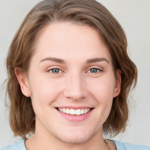 Joyful white young-adult female with medium  brown hair and blue eyes