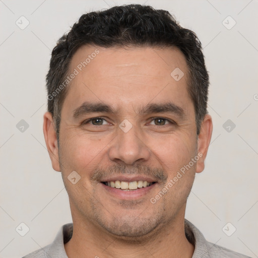 Joyful white young-adult male with short  black hair and brown eyes