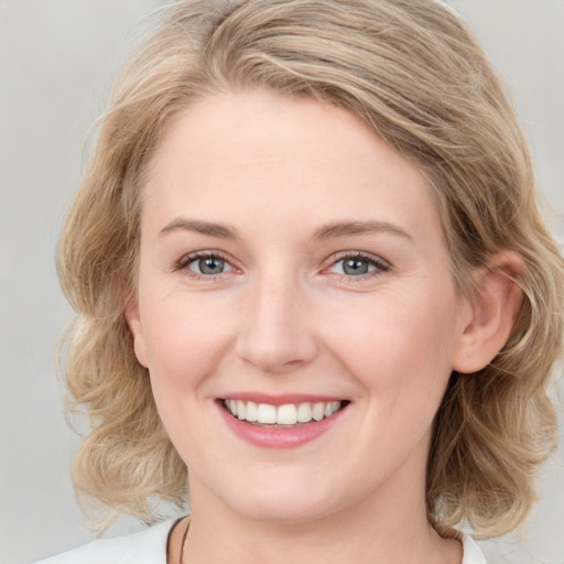 Joyful white young-adult female with medium  brown hair and blue eyes