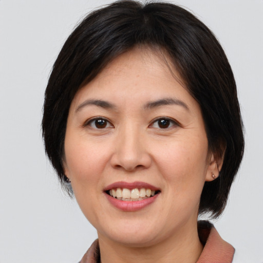 Joyful white adult female with medium  brown hair and brown eyes