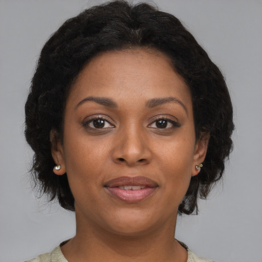 Joyful black adult female with medium  brown hair and brown eyes