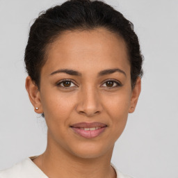 Joyful latino young-adult female with short  brown hair and brown eyes