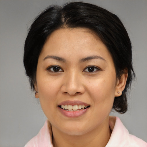 Joyful asian adult female with medium  brown hair and brown eyes