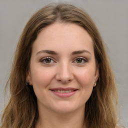 Joyful white young-adult female with long  brown hair and green eyes