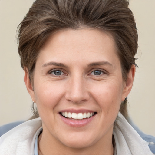 Joyful white young-adult female with short  brown hair and grey eyes