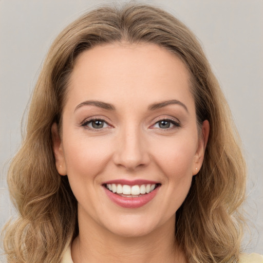 Joyful white young-adult female with long  brown hair and green eyes