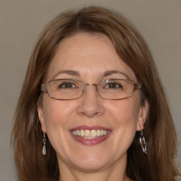 Joyful white adult female with medium  brown hair and blue eyes