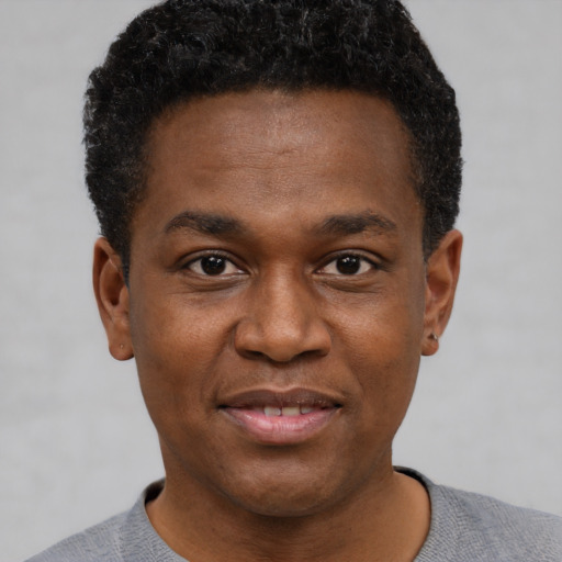 Joyful black young-adult male with short  black hair and brown eyes