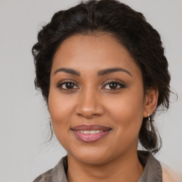 Joyful latino young-adult female with medium  brown hair and brown eyes