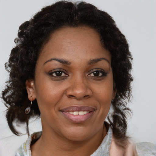 Joyful black adult female with short  brown hair and brown eyes