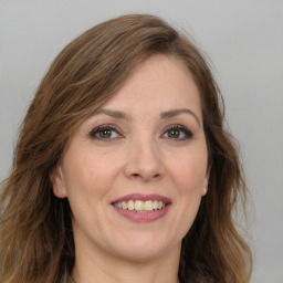 Joyful white young-adult female with long  brown hair and green eyes