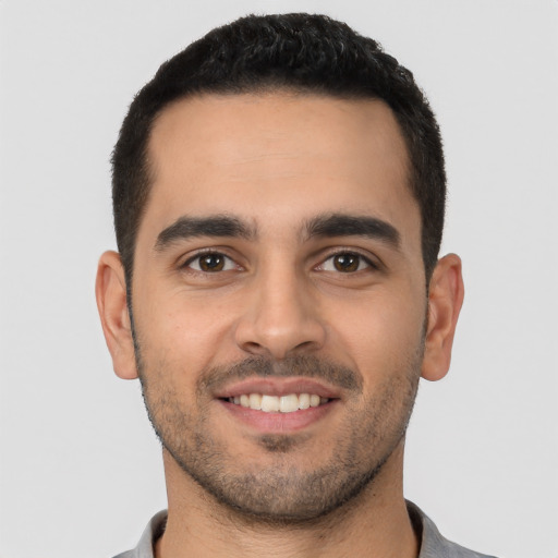 Joyful white young-adult male with short  black hair and brown eyes