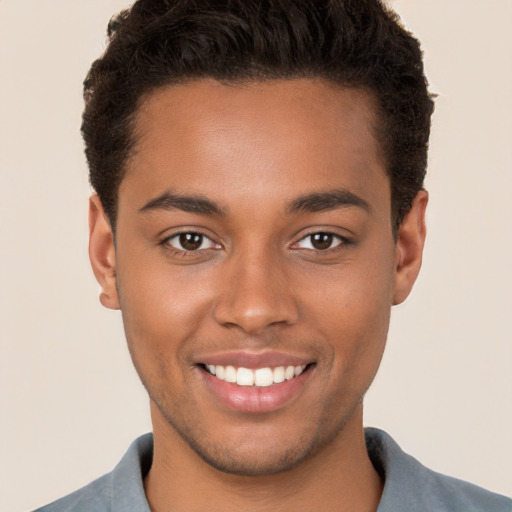 Joyful black young-adult male with short  brown hair and brown eyes