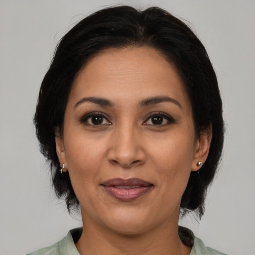 Joyful latino adult female with medium  brown hair and brown eyes