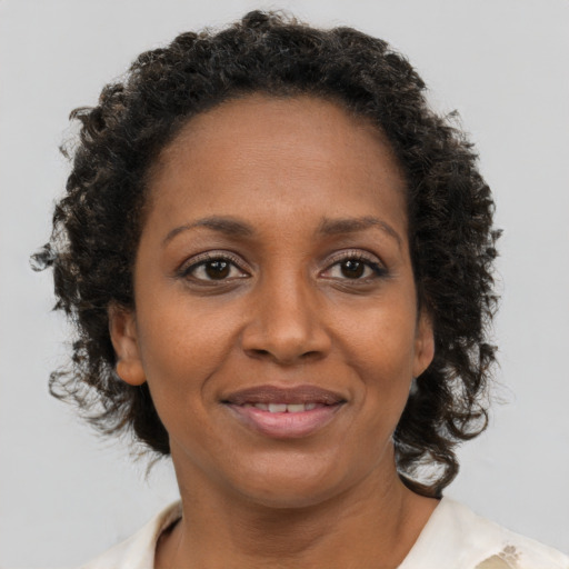 Joyful black adult female with medium  brown hair and brown eyes