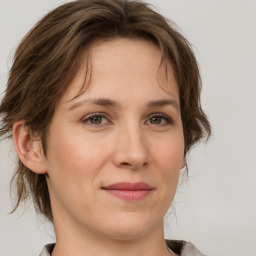 Joyful white adult female with medium  brown hair and grey eyes