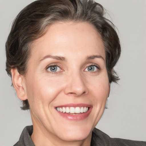 Joyful white adult female with medium  brown hair and grey eyes