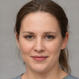 Joyful white young-adult female with medium  brown hair and grey eyes