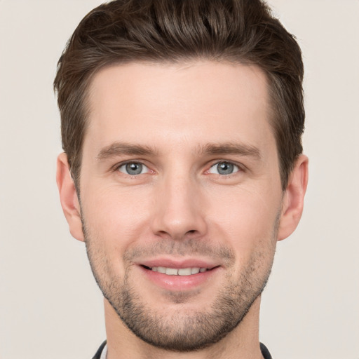 Joyful white young-adult male with short  brown hair and grey eyes