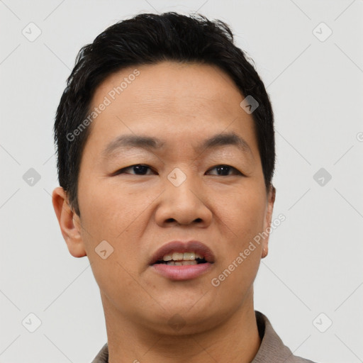Joyful asian young-adult male with short  brown hair and brown eyes