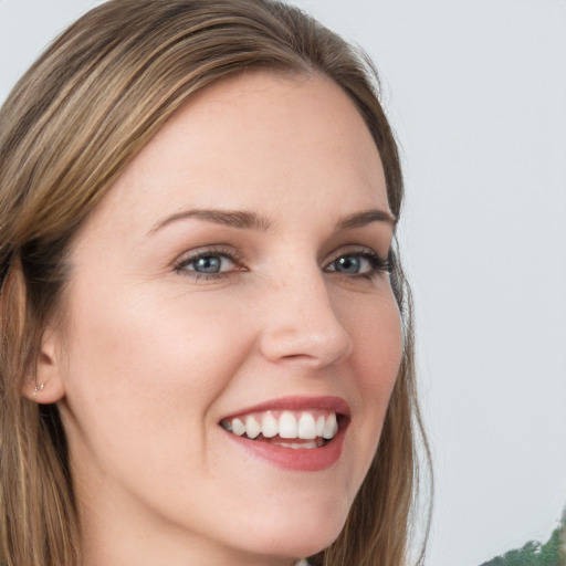 Joyful white young-adult female with long  brown hair and green eyes