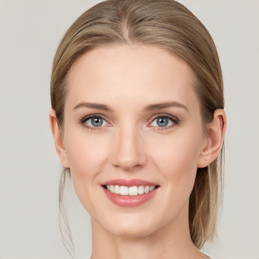 Joyful white young-adult female with medium  brown hair and grey eyes