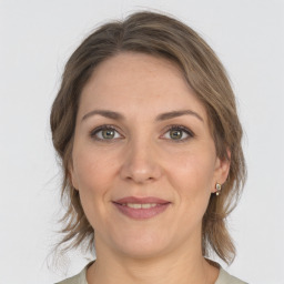 Joyful white young-adult female with medium  brown hair and grey eyes