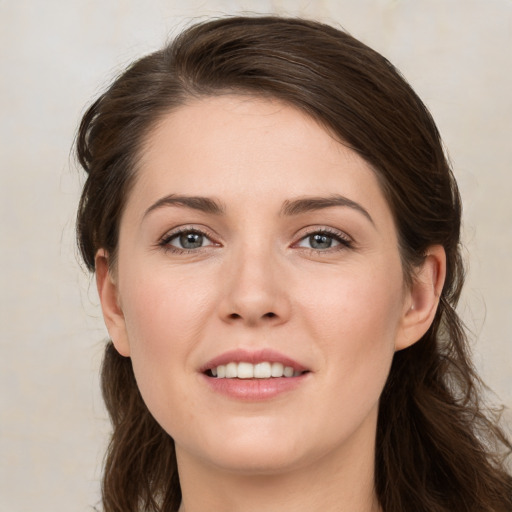 Joyful white young-adult female with medium  brown hair and grey eyes